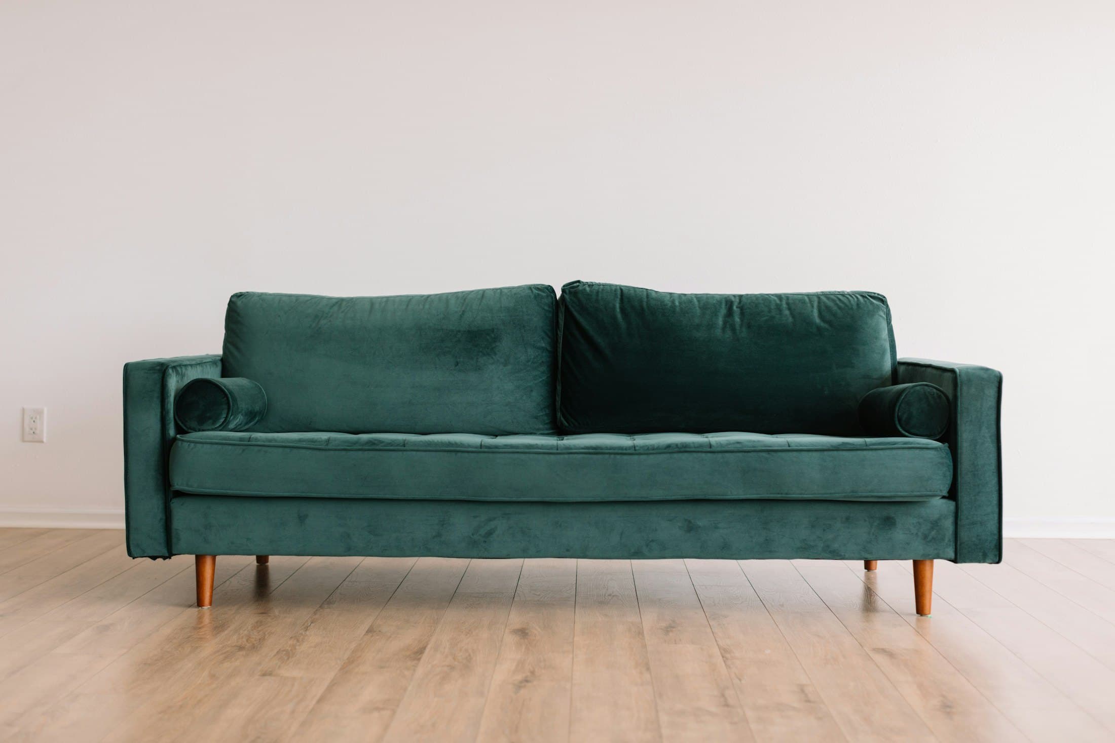 Green sofa in a warm, wood-accented interior